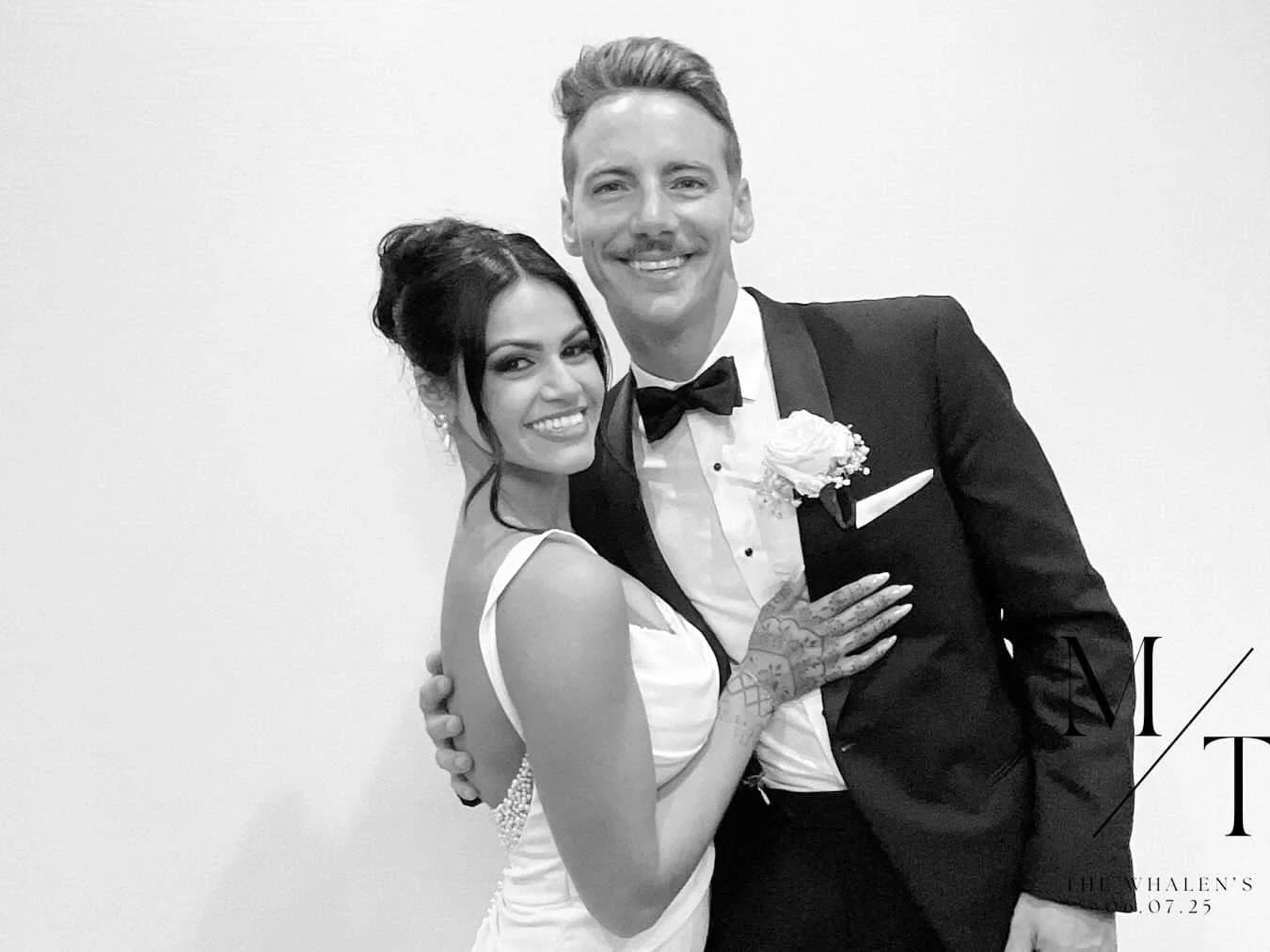 A bride and groom smiling together in a crisp black and white photo booth portrait