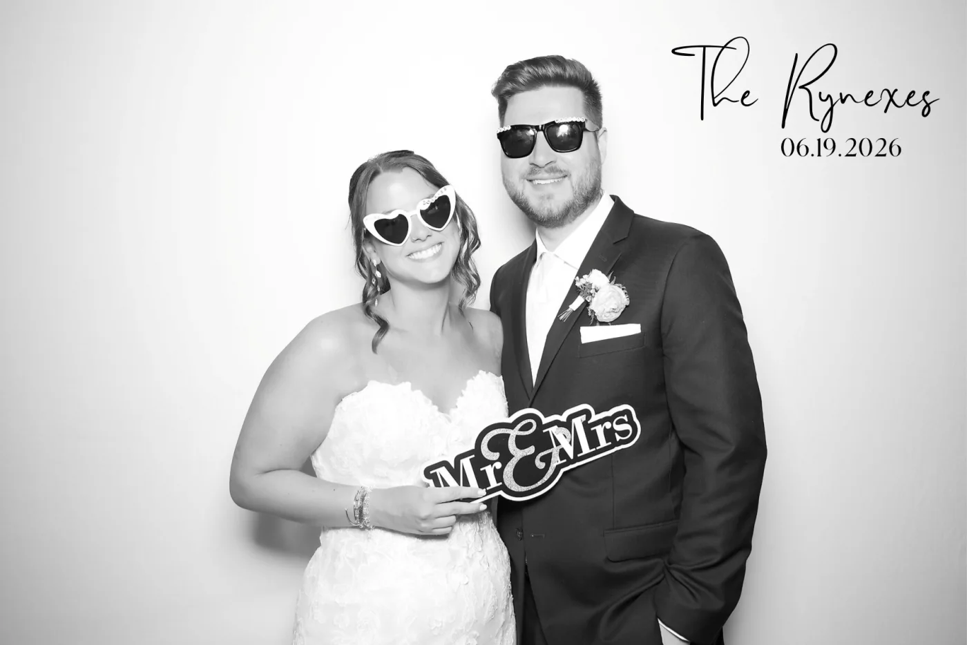 Newlyweds smiling together in a black and white photo booth portrait
